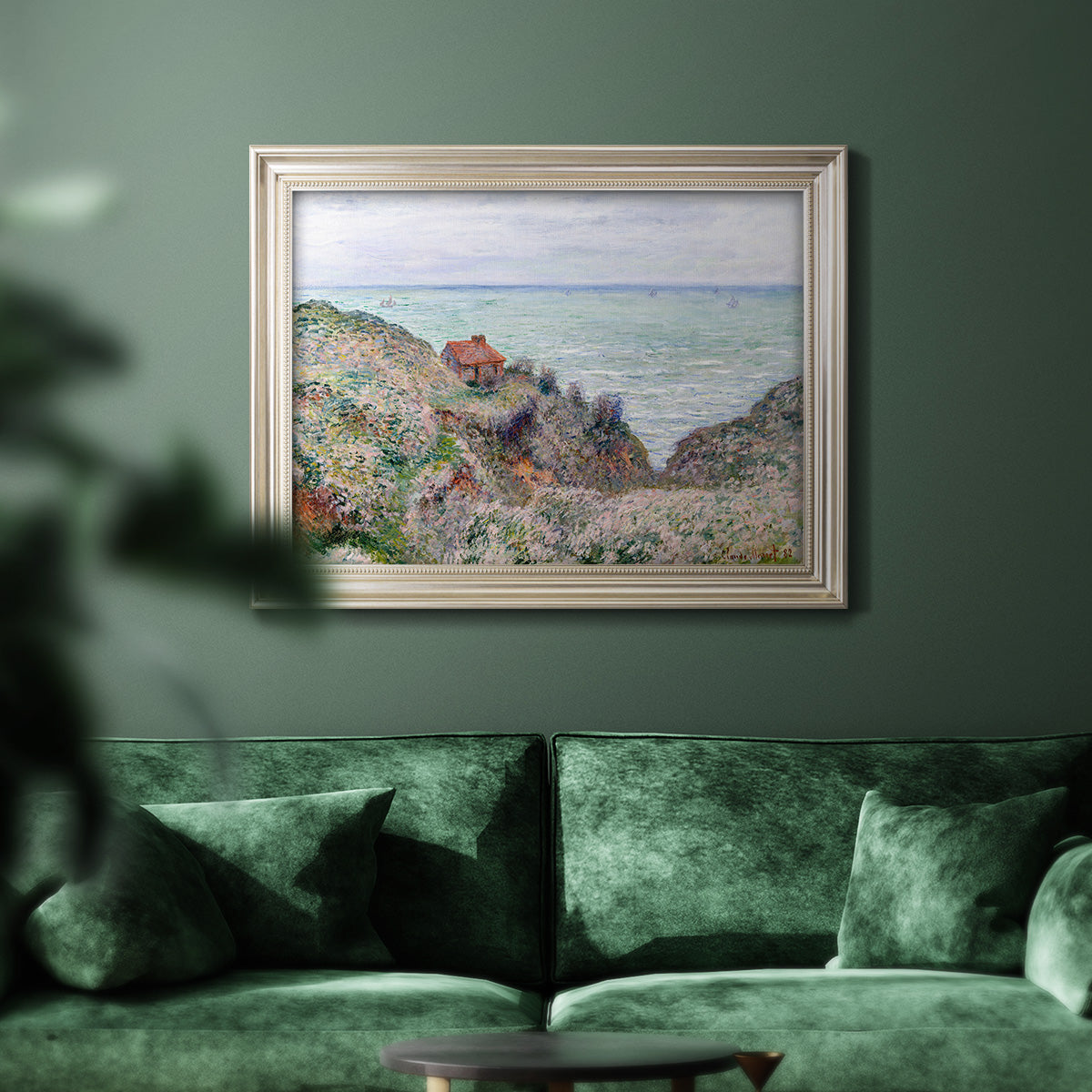 Impressionist coastal watch cabin scene by Claude Monet in an ornate champagne frame displayed in a dark-toned interior setting.