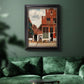 Realist city street scene by Johannes Vermeer in an ornate black frame with gilded inner detail displayed in a dark-toned interior setting.