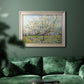 Impressionist white-blossomed orchard landscape by Vincent van Gogh in an ornate champagne frame displayed in a dark-toned interior setting.