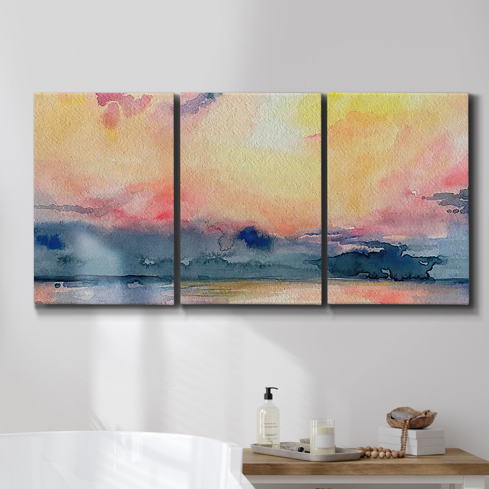 Three-panel canvas wall art featuring prismatic watercolor coastal seascape, displayed in a bathroom above a bathtub.