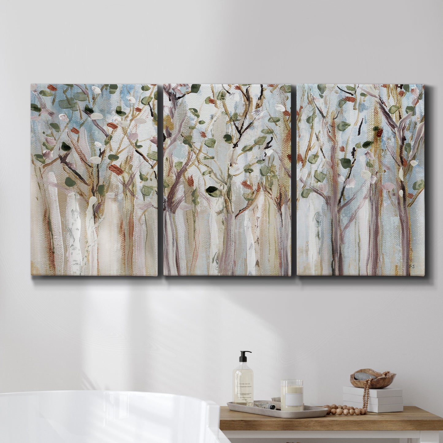 Three-panel canvas wall art featuring bare birch trees in winter forest, displayed in a bathroom above a bathtub.