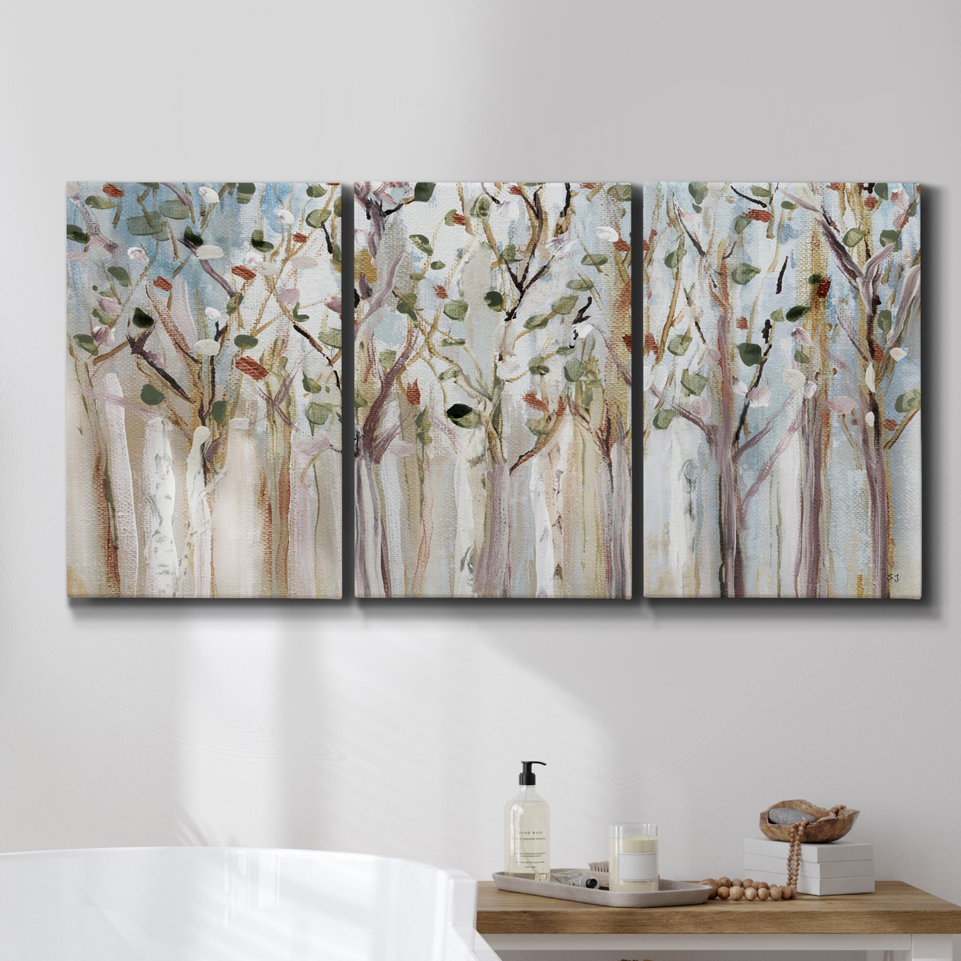 Three-panel canvas wall art featuring bare birch trees in winter forest, displayed in a bathroom above a bathtub.