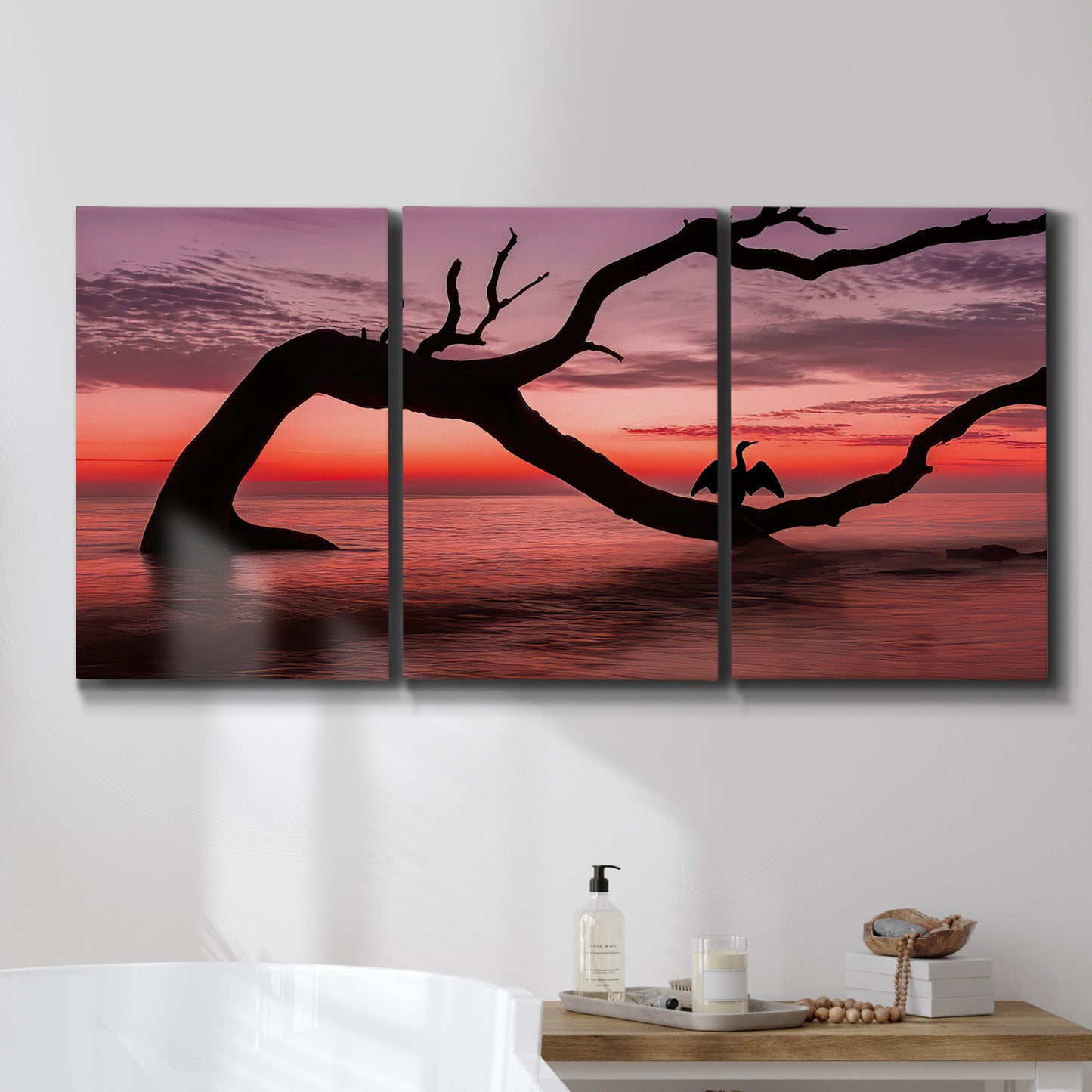 Three-panel canvas wall art featuring sunset beach photography, displayed in a bathroom above a bathtub.