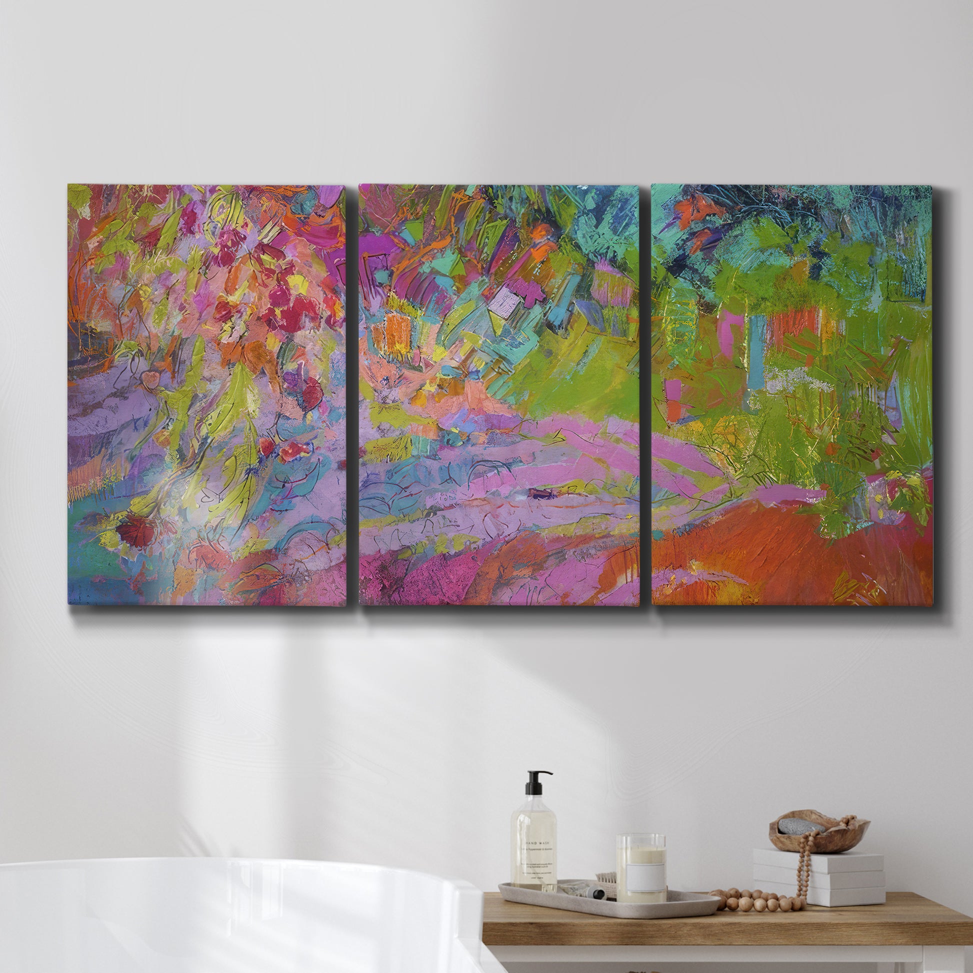 Three-panel canvas wall art featuring vibrant abstract with dramatic motion, displayed in a bathroom above a bathtub.