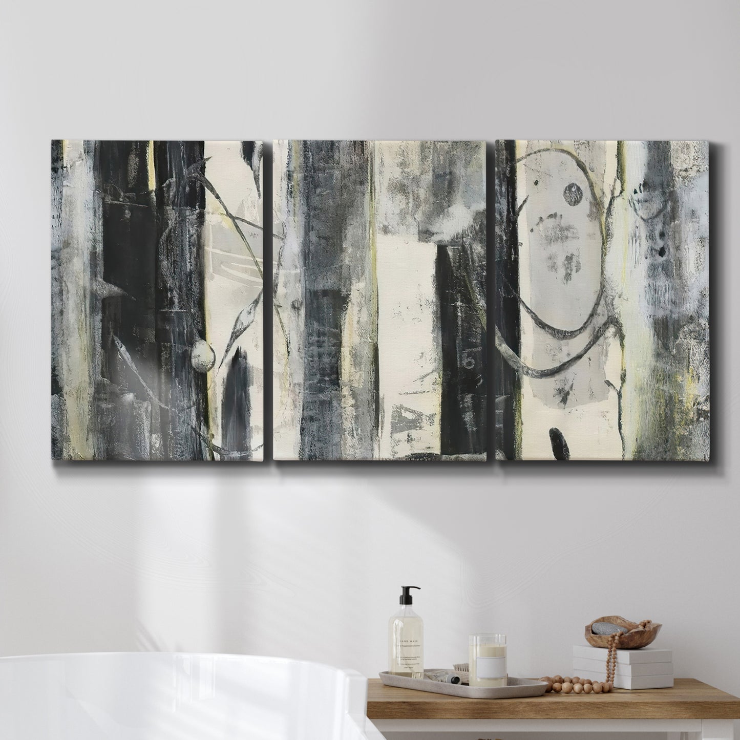 Three-panel canvas wall art featuring vertical abstract tree forms, displayed in a bathroom above a bathtub.