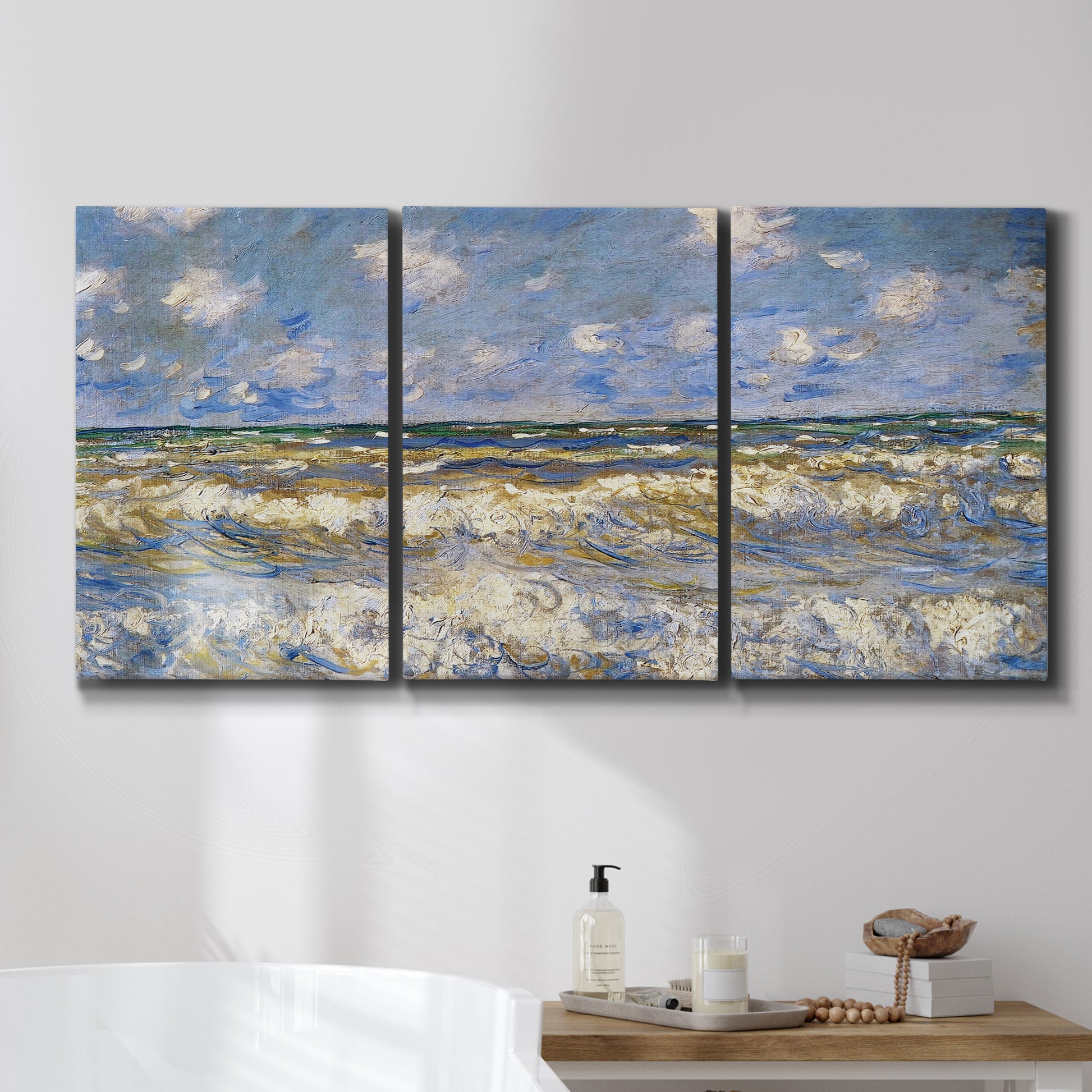 Three-panel canvas wall art featuring rough sea with crashing waves, displayed in a bathroom above a bathtub.