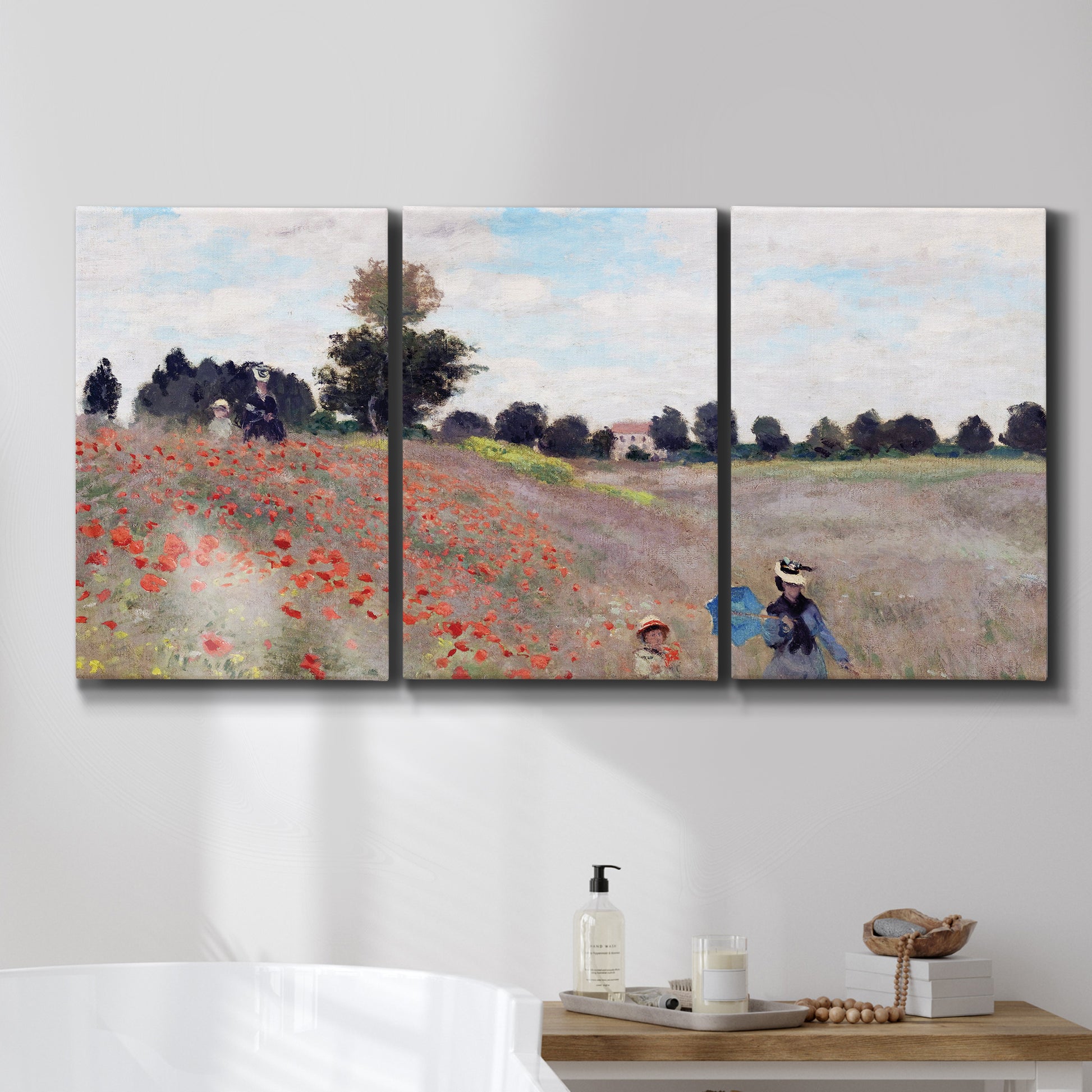 Three-panel canvas wall art featuring poppy field stretching across meadow, displayed in a bathroom above a bathtub.