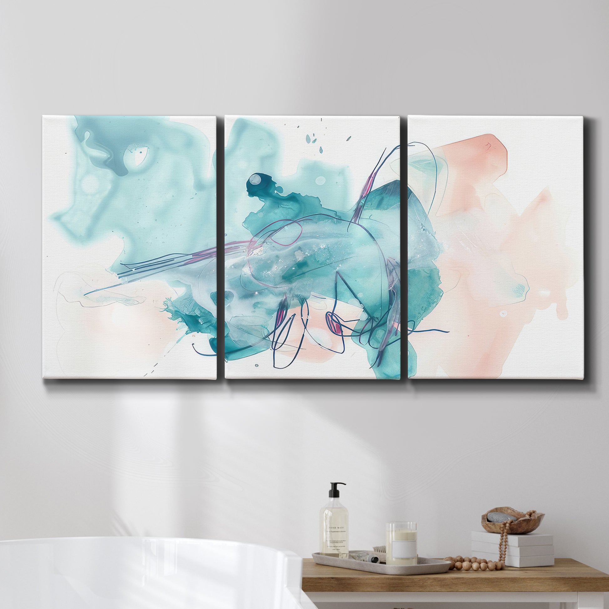 Three-panel canvas wall art featuring soft abstract watercolor forms, displayed in a bathroom above a bathtub.