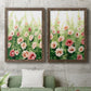 Set of two walnut barnwood framed canvas prints depicting a coordinated art pair of a field of pink coral and white flowers rendered as luminous impressionistic floral paintings above a sofa in a modern living room.