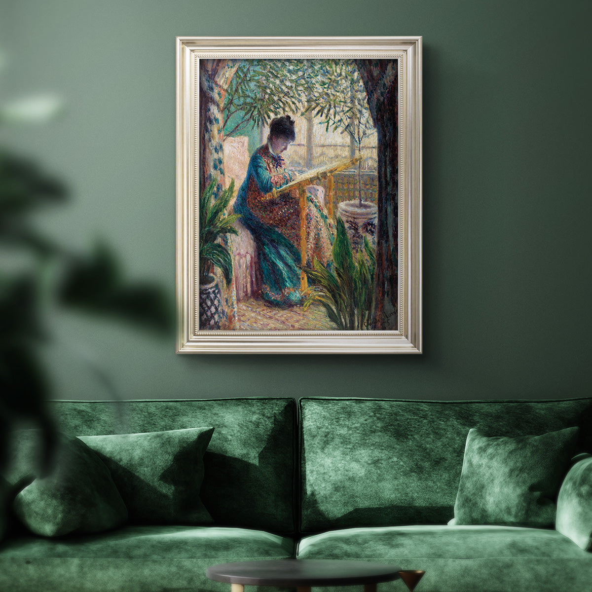 Impressionist portrait of Madame Monet sewing by Claude Monet in an ornate champagne frame displayed in a dark-toned interior setting.