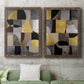 Set of two walnut barnwood framed canvas prints depicting a coordinated art pair of interlocking black gray cream and gold geometric sections rendered as structured modern abstracts above a sofa in a modern living room.