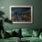 Impressionist nighttime Paris street scene by Camille Pissarro in an ornate champagne frame displayed in a dark-toned interior setting.