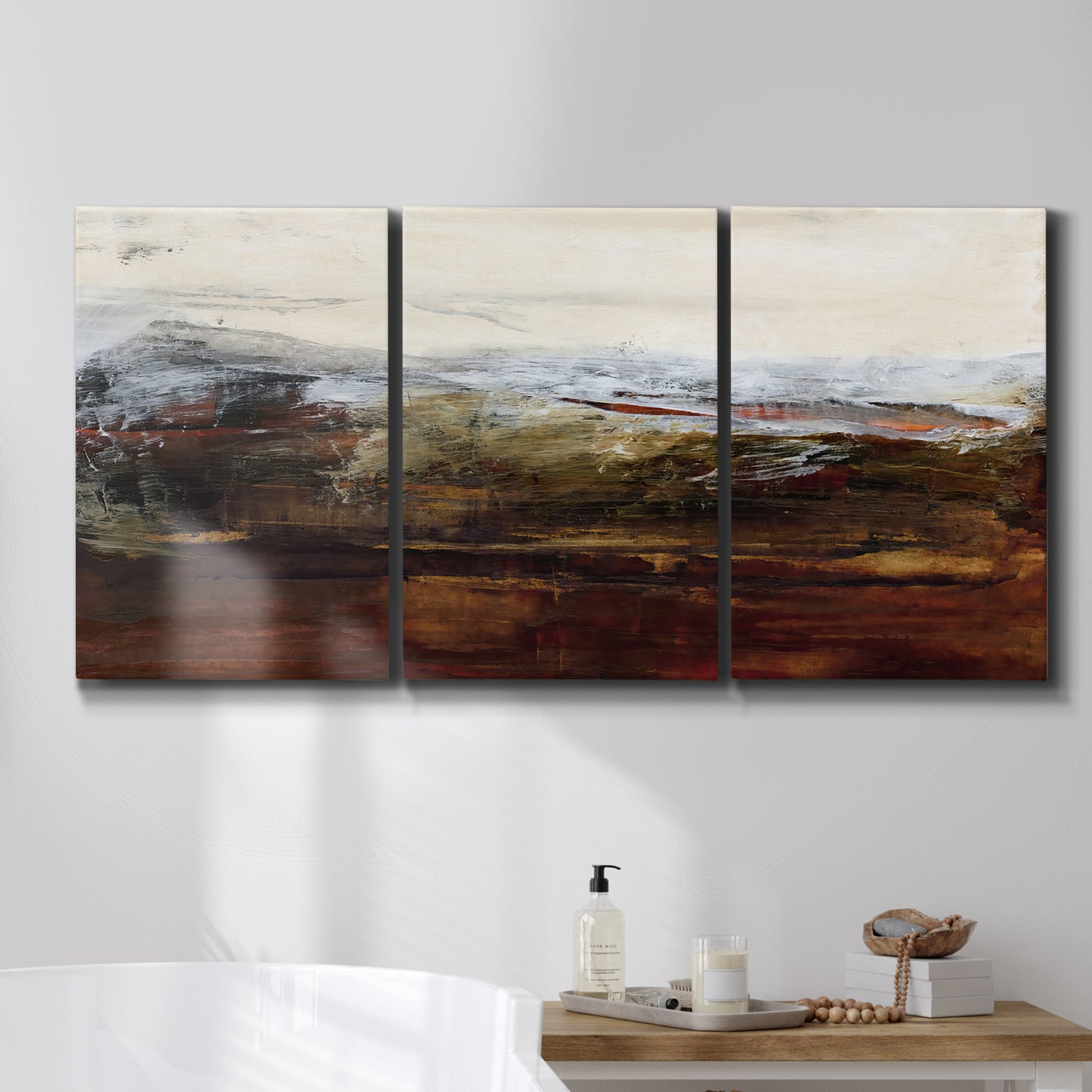 Three-panel canvas wall art featuring rustic abstract landscape exploration, displayed in a bathroom above a bathtub.