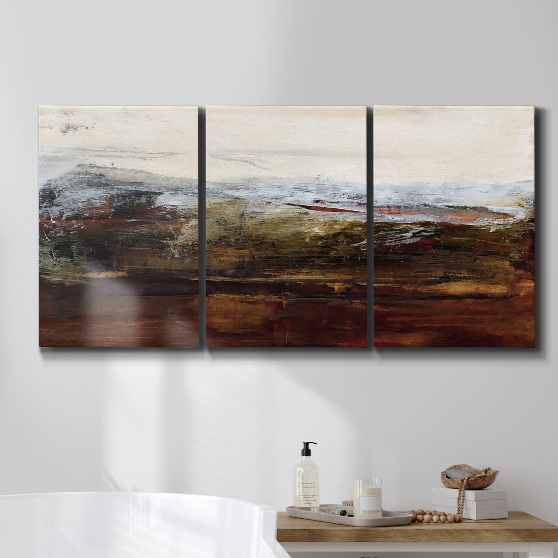 Three-panel canvas wall art featuring rustic abstract landscape exploration, displayed in a bathroom above a bathtub.
