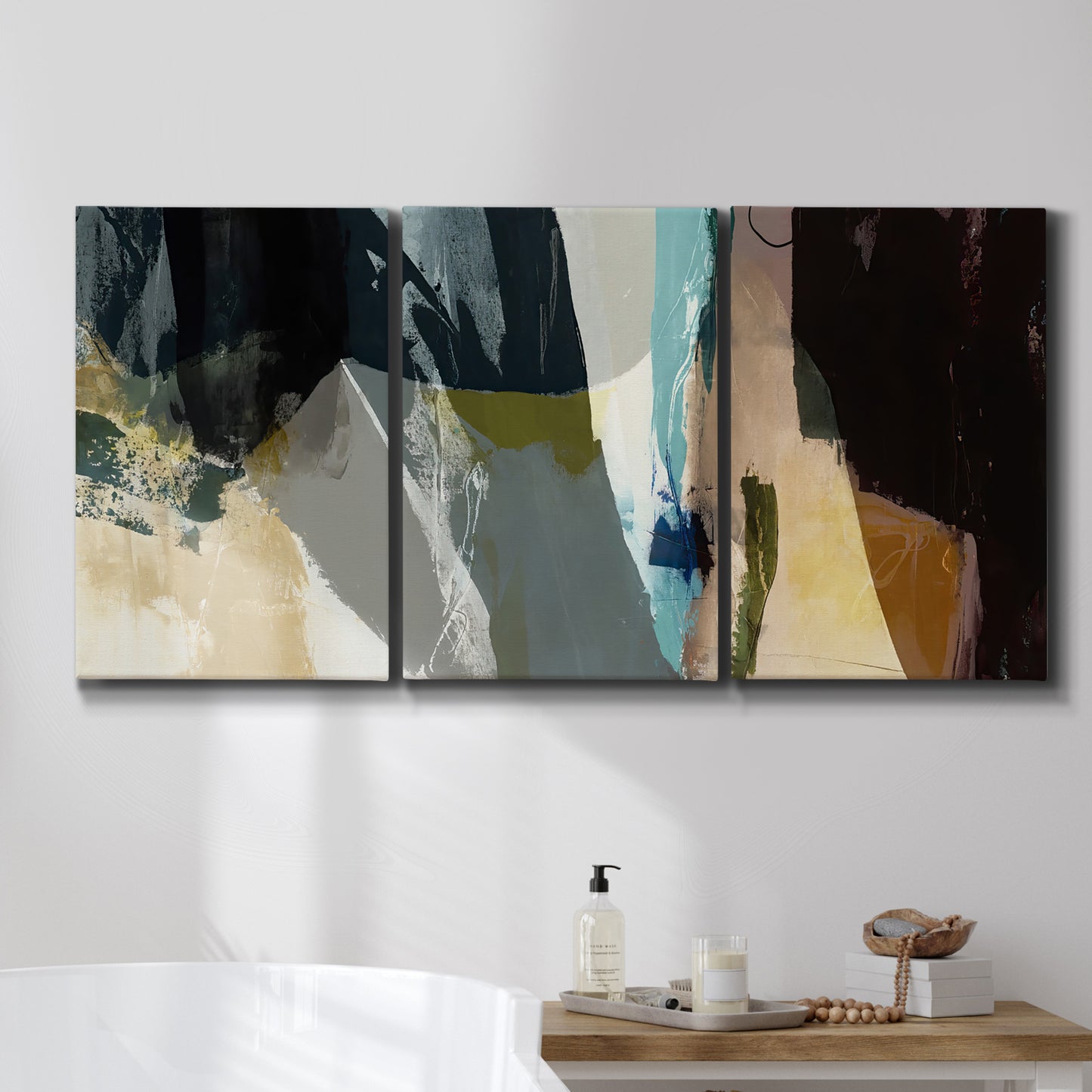 Three-panel canvas wall art featuring layered neutral abstract textures, displayed in a bathroom above a bathtub.