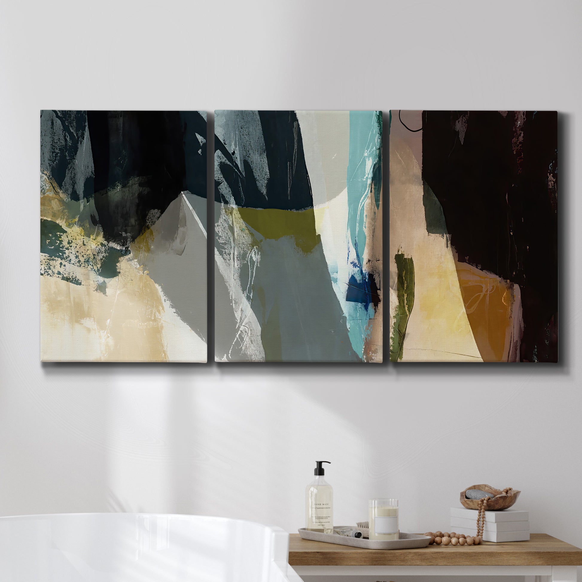 Three-panel canvas wall art featuring layered neutral abstract textures, displayed in a bathroom above a bathtub.
