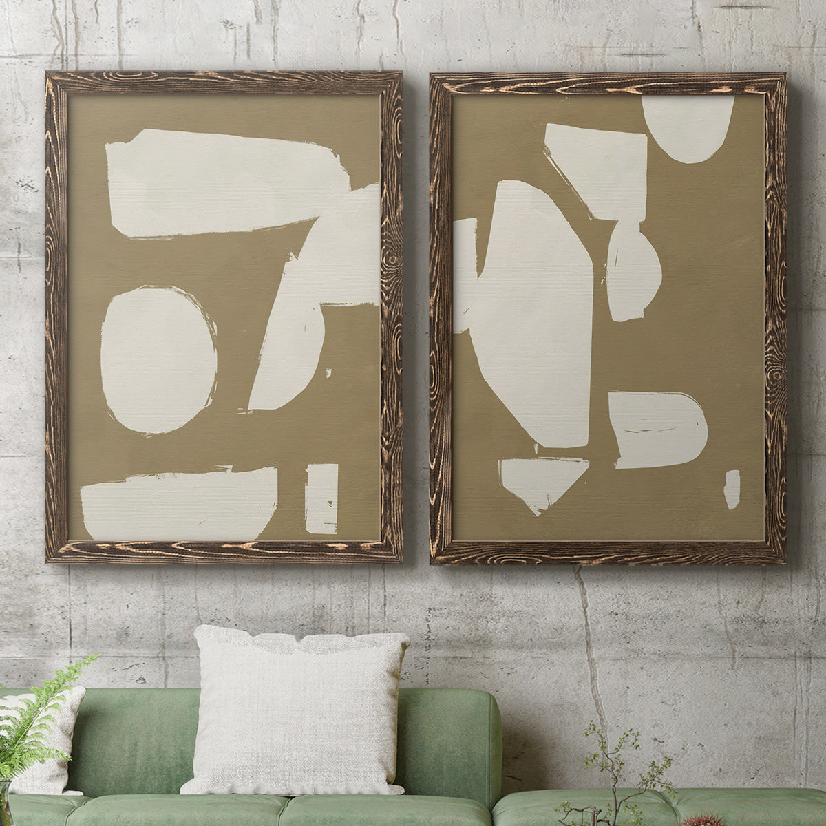 Set of two walnut barnwood framed canvas prints depicting a coordinated art pair of irregular white cutout-like shapes on taupe grounds rendered as bold minimalist shape abstracts above a sofa in a modern living room.