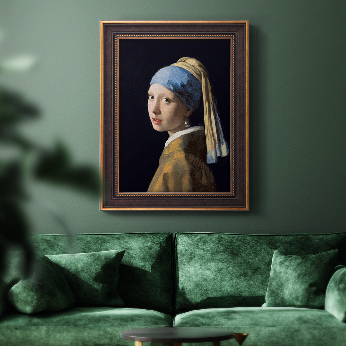Iconic portrait of a girl wearing a pearl earring by Johannes Vermeer in an ornate bronzed mahogany wood frame displayed in a dark-toned interior setting.