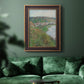 Impressionist landscape view of Vétheuil by Claude Monet in an ornate bronzed mahogany wood frame displayed in a dark-toned interior setting.