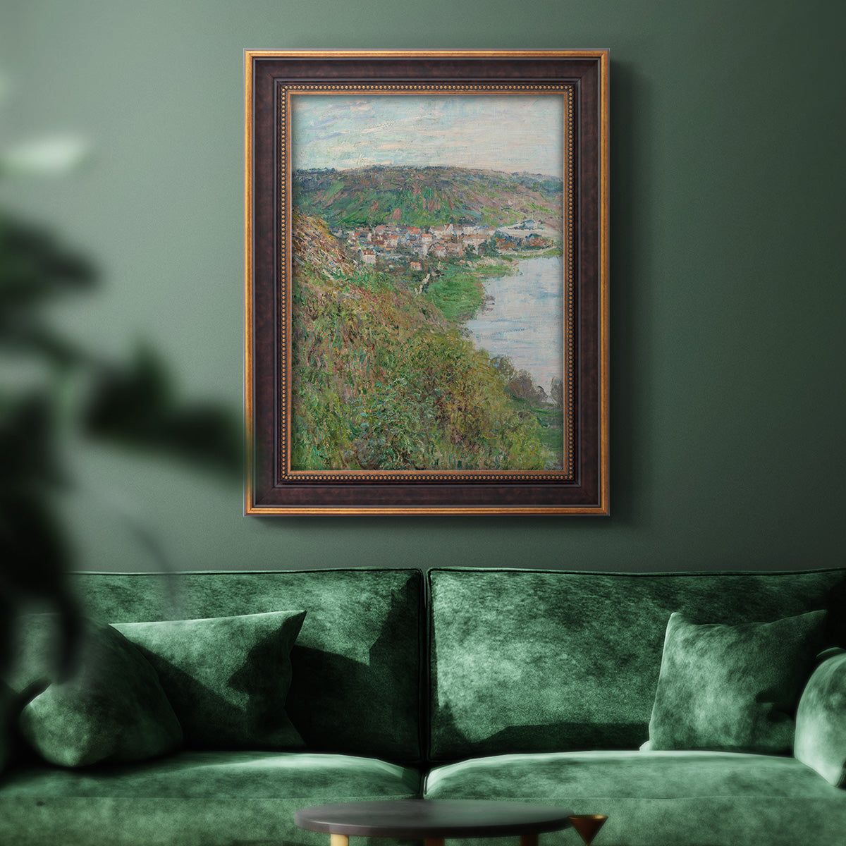 Impressionist landscape view of Vétheuil by Claude Monet in an ornate bronzed mahogany wood frame displayed in a dark-toned interior setting.