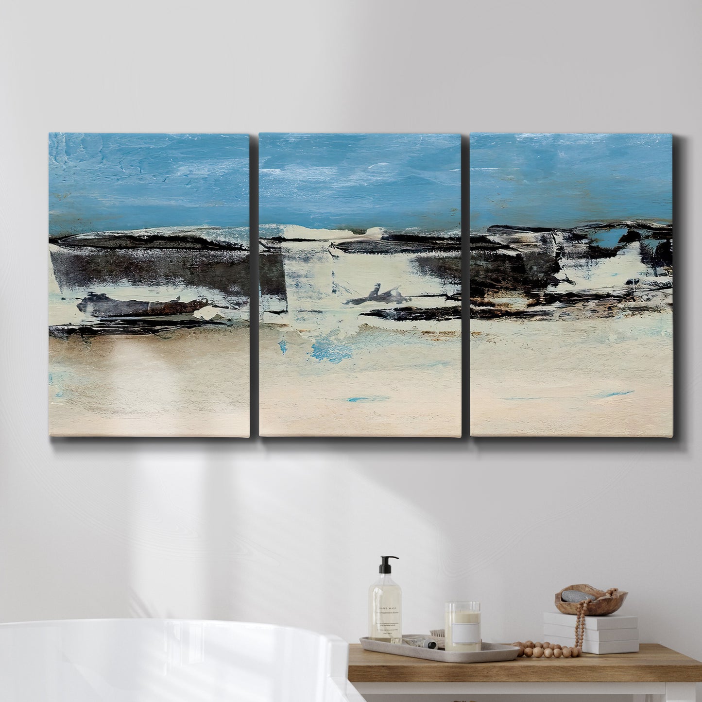 Three-panel canvas wall art featuring abstract bridge landscape in cyan, displayed in a bathroom above a bathtub.