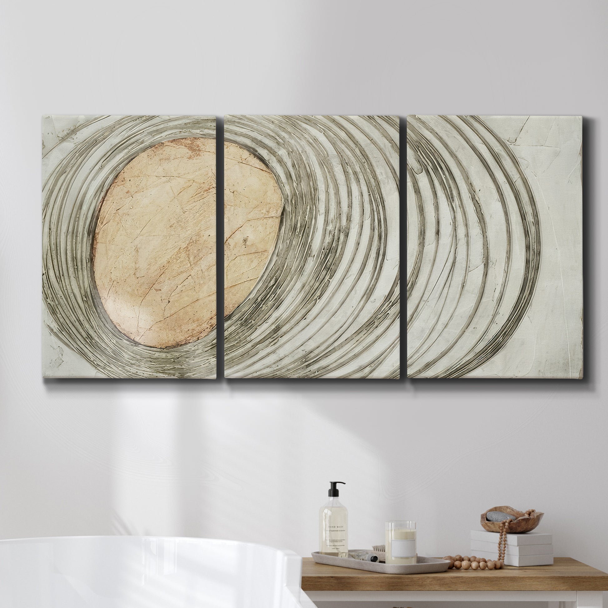 Three-panel canvas wall art featuring circular abstract energy forms, displayed in a bathroom above a bathtub.