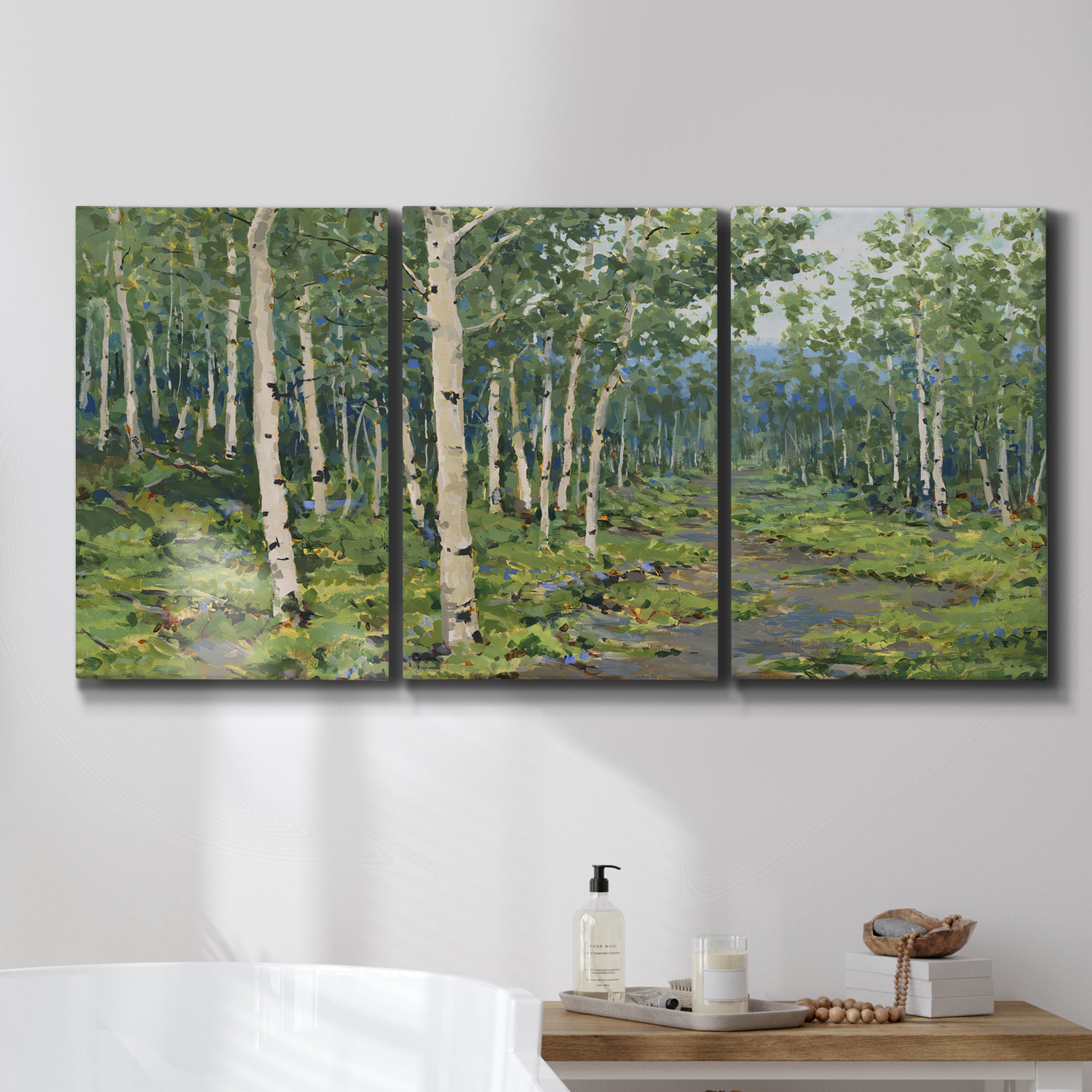 Three-panel canvas wall art featuring woodland forest scene with tall trees, displayed in a bathroom above a bathtub.