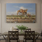 Canvas art print featuring figures and animals along riverbank with desert landscape, showcased as a statement wall artwork