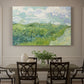 Canvas art print featuring a vivid green wheat field stretching across rolling landscape under pale sky, showcased as a statement wall artwork