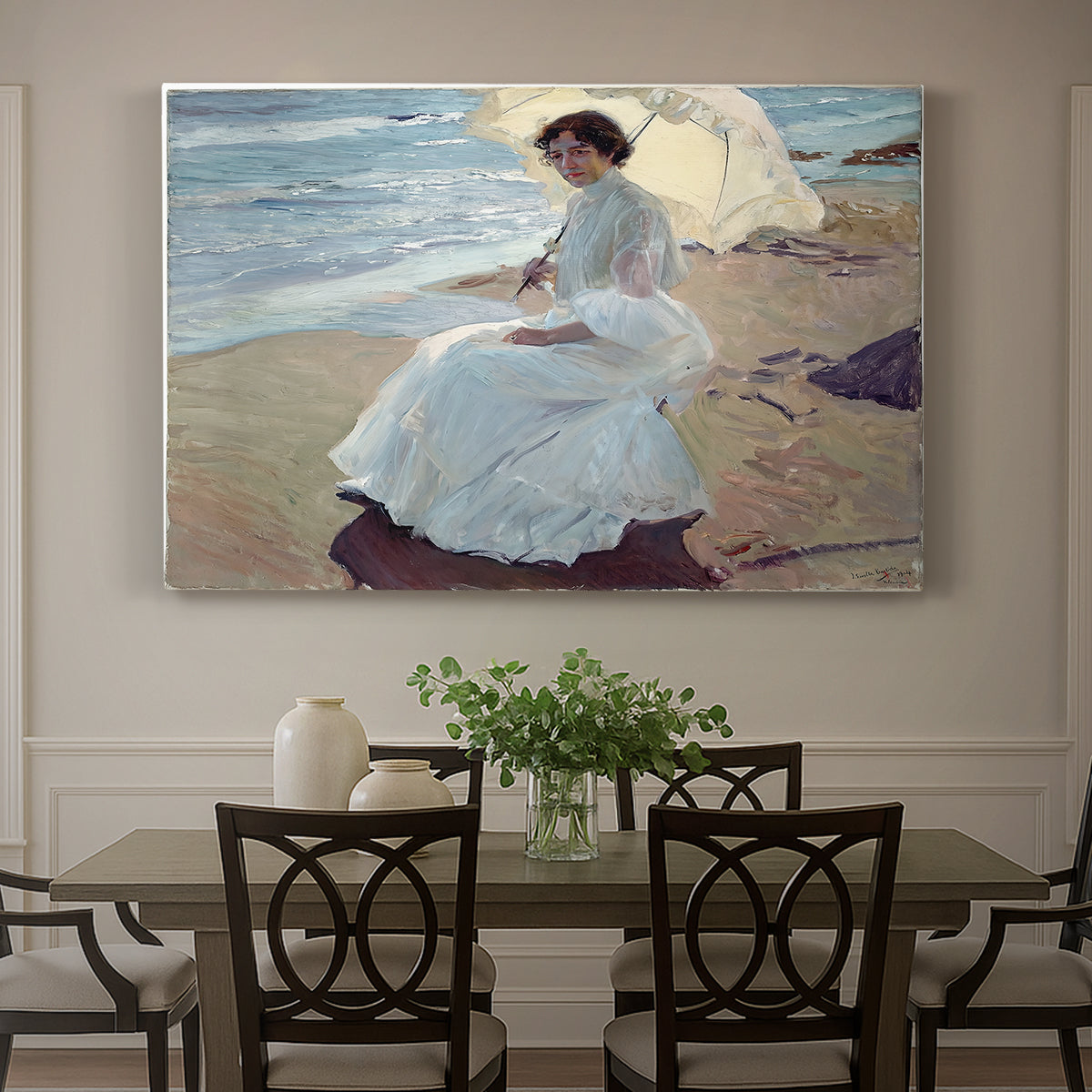 Canvas art print featuring a woman seated on beach in flowing white dress beside water, showcased as a statement wall artwork