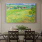 Canvas art print featuring a rolling hillside landscape with houses and fields under wide sky, showcased as a statement wall artwork