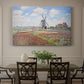 Canvas art print featuring colorful rows of tulip fields leading toward distant windmill, showcased as a statement wall artwork