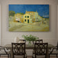 Canvas art print featuring a street view with bright yellow house and neighboring buildings under blue sky, showcased as a statement wall artwork