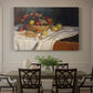 Canvas art print featuring an arrangement of apples and grapes on table with soft natural light, showcased as a statement wall artwork