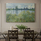 Canvas art print featuring a riverbank landscape with water, trees, and distant village buildings, showcased as a statement wall artwork