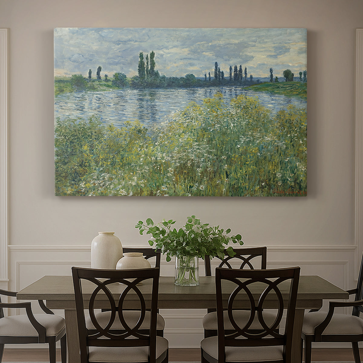 Canvas art print featuring a riverbank landscape with water, trees, and distant village buildings, showcased as a statement wall artwork