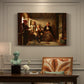 Canvas art print featuring a group of rural villagers gathered inside a dimly lit wooden interior in conversation, presented within a refined interior setting