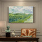 Canvas art print featuring a vivid green wheat field stretching across rolling landscape under pale sky, presented within a refined interior setting
