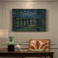 Canvas art print featuring a night river scene with reflections of lights and stars across water, presented within a refined interior setting