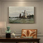 Canvas art print featuring a single windmill beside water with surrounding buildings and sky, presented within a refined interior setting