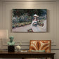 Canvas art print featuring a young girl seated in lush garden surrounded by blooming flowers, presented within a refined interior setting