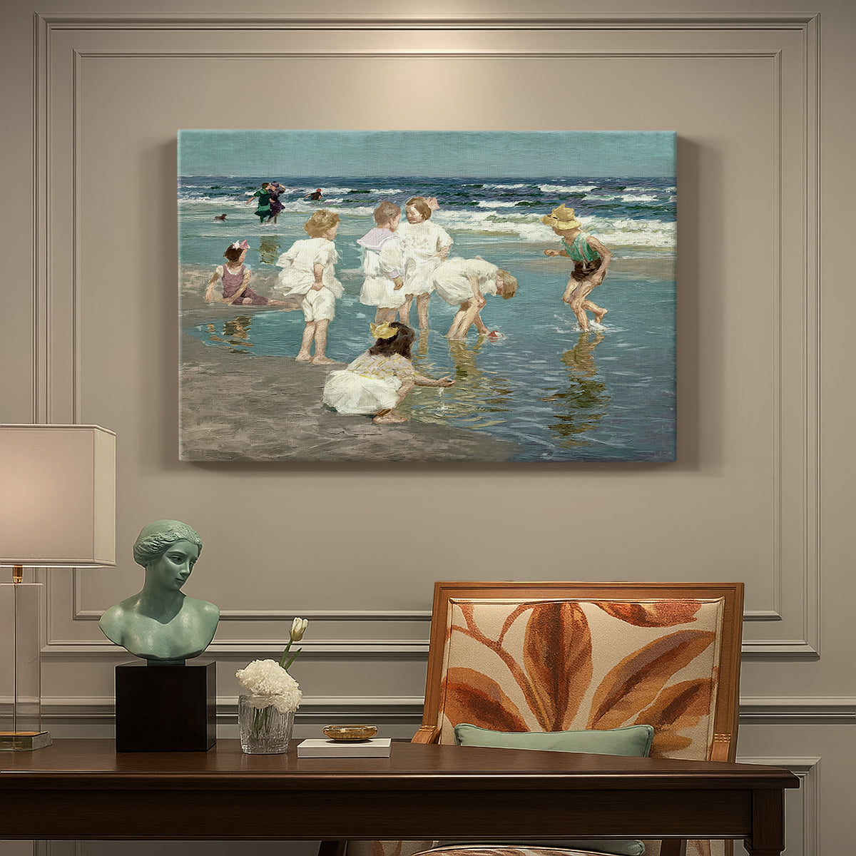 Canvas art print featuring people relaxing and wading in shallow ocean water along a sunny beach, presented within a refined interior setting