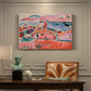 Canvas art print featuring a colorful coastal townscape with buildings, water, and bright rooftops, presented within a refined interior setting