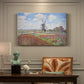 Canvas art print featuring colorful rows of tulip fields leading toward distant windmill, presented within a refined interior setting