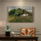 Canvas art print featuring a farmhouse surrounded by meadow filled with wildflowers and greenery, presented within a refined interior setting
