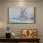 Canvas art print featuring a windmill beside water in quiet town landscape, presented within a refined interior setting