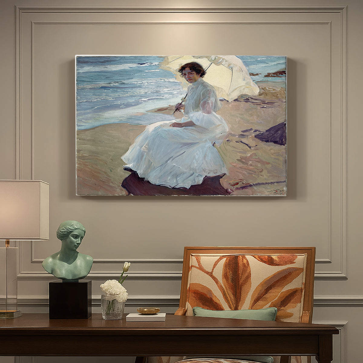 Canvas art print featuring a woman seated on beach in flowing white dress beside water, presented within a refined interior setting