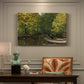 Canvas art print featuring a young boy fishing beside calm water surrounded by greenery, presented within a refined interior setting