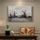 Canvas art print featuring windmills standing beside water under open sky in rural landscape, presented within a refined interior setting