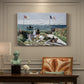 Canvas art print featuring a seaside garden with flowers, flags, and figures overlooking the water, presented within a refined interior setting